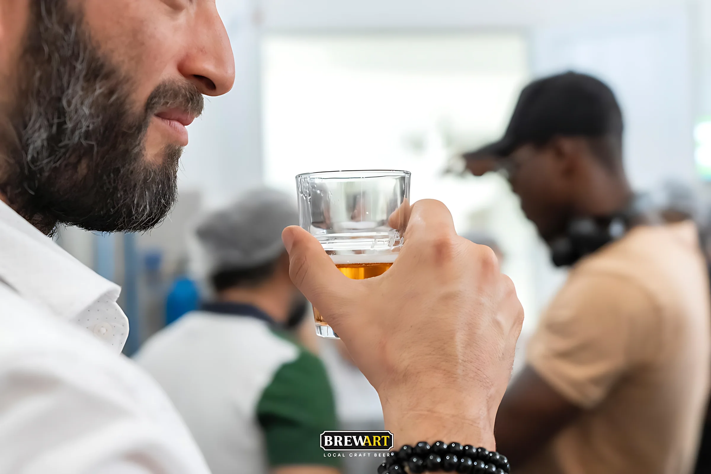 Bir ziyaretçi bardaktaki birayı kokluyor